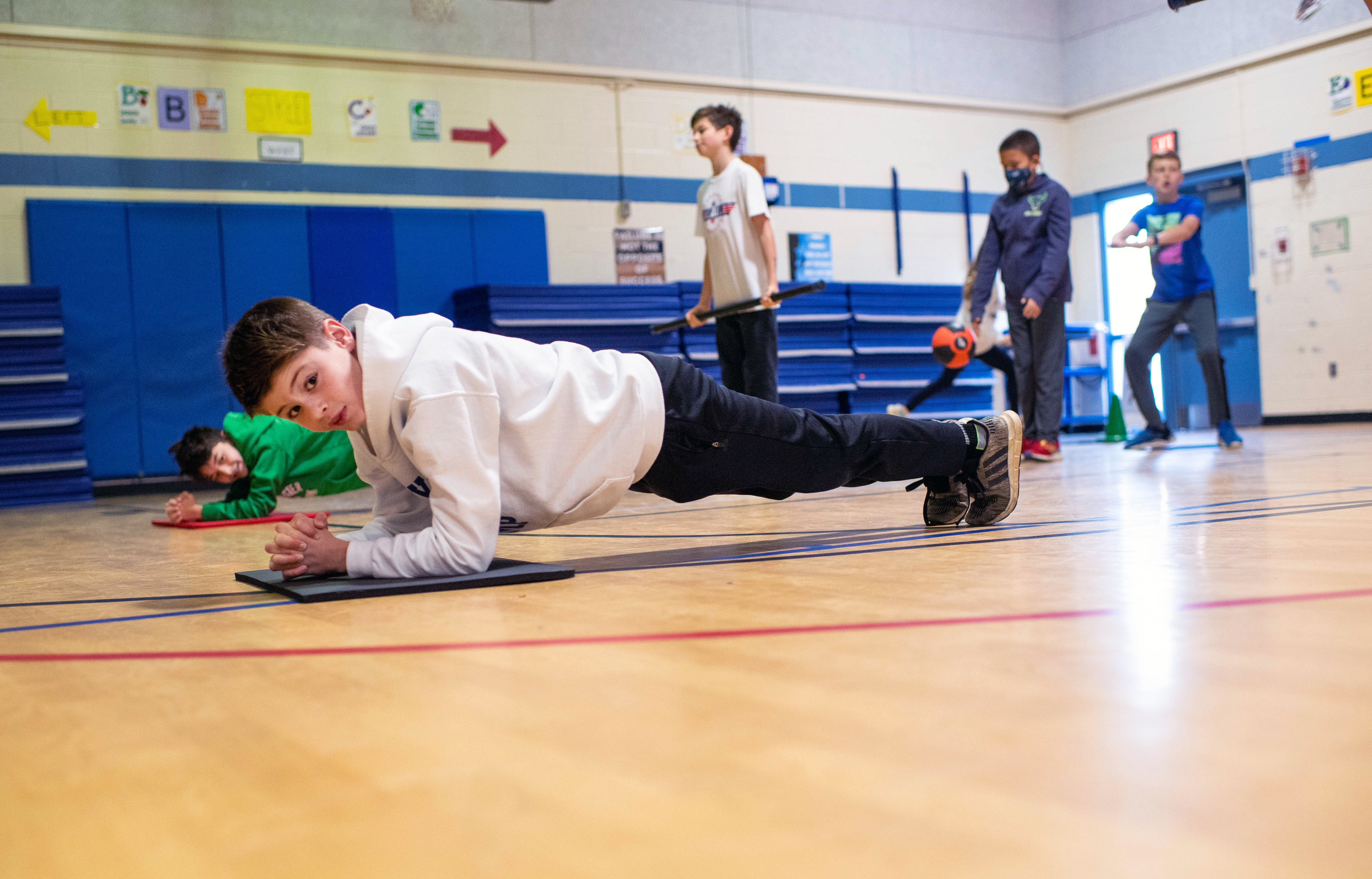 A student holds a plank pose during a Fitness Warrior morning workout at Chesterbrook Elementary.